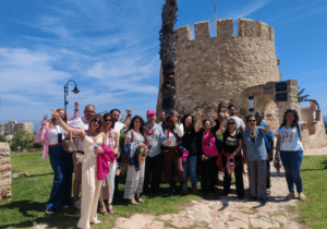 Grupo de asistentes posando junto a la Torre del Moro durante una experiencia de Miss Flamingo en Torrevieja