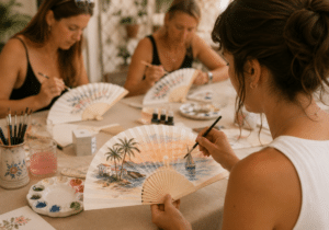 Mujer pintando un abanico a mano durante un taller creativo al aire libre en Torrevieja